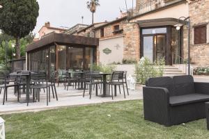 蒙塔约内Hotel Le Macine的建筑物前有桌椅的露台