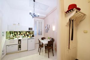 eine Küche und ein Esszimmer mit einem Tisch und ein Zimmer mit einer Küche in der Unterkunft Green Door Family Apartment in Budapest