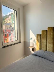 a bedroom with a bed and a window at Agave Room Rental in Riomaggiore
