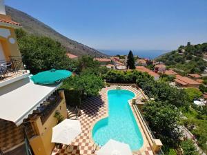 an overhead view of a swimming pool with umbrellas at Old Olive House in Kouroukláta