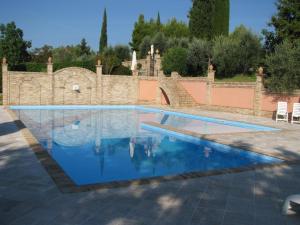 a swimming pool in front of a stone wall at Agriturismo La Campana in Montefiore dellʼAso