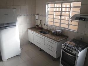 a kitchen with a sink and a stove and a refrigerator at Residencial Castelo Branco in Campinas