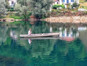 un hombre en un barco en un lago de pesca en Peaceful Oasis - house for rest and relaxation, en Bosanska Krupa