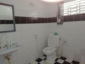uma casa de banho com um WC, um lavatório e um espelho. em Sunny House Paje II em Paje