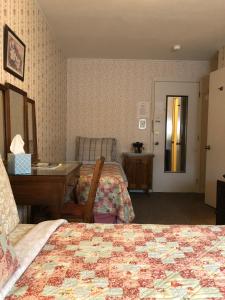 a hotel room with two beds and a table and a desk at The Courtland Hotel & Spa in Fort Scott