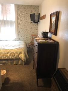 a bedroom with a bed and a dresser with a mirror at The Courtland Hotel & Spa in Fort Scott