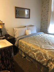 1 dormitorio con cama, mesa y ventana en The Courtland Hotel & Spa en Fort Scott