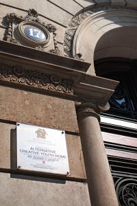 バルセロナにあるオルターナティブ クリエイティブ ユース ホステル バルセロナの時計付きの建物側の看板