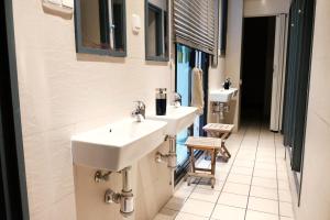 a bathroom with two sinks and a row of mirrors at Alternative Creative Youth Hostel Barcelona in Barcelona