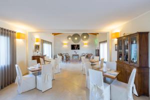 a living room with white chairs and a dining room at Casale Santa Maria Country House in Mosciano SantʼAngelo