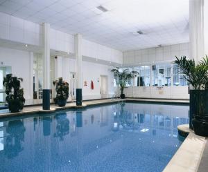 uma grande piscina com água azul num edifício em The Palace Hotel Buxton & Spa em Buxton