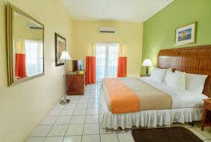 a hotel room with a bed and a mirror at Bay Gardens Inn in Gros Islet