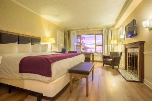 a hotel room with a large bed and a window at Hôtel le Manoir Baie-Comeau in Baie-Comeau