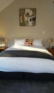 a bedroom with a large bed with a table at The Ohakune Central Motels in Ohakune