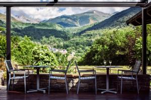 una mesa y sillas con vistas a las montañas en Hostal La Plaça en Erill la Vall