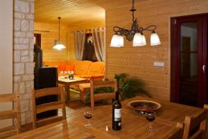 Sala de estar con mesa y botella de vino en Ferienhaus Buchholz, en Warnitz