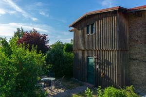 ein kleines Gebäude mit einer grünen Tür und einem Tisch in der Unterkunft Ferienwohnung Buchholz in Warnitz