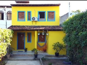 a yellow house with blue windows at Suites Casa De Ban in Lençóis