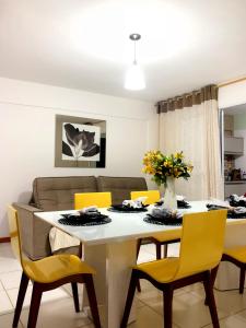 a dining room with a table and yellow chairs at Lindo Village Imbassai in Mata de Sao Joao