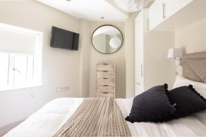a bedroom with a bed with a mirror and a tv at The Soho Loft - Elegant & Modern 1BDR in London