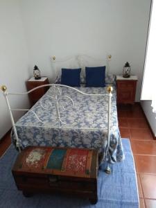 a bedroom with a bed with a blue comforter at Casa dos Teares in Aldeia das Dez