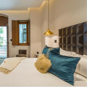 a bedroom with a large white bed with blue pillows at Casa Prim Hotel Boutique in Mexico City