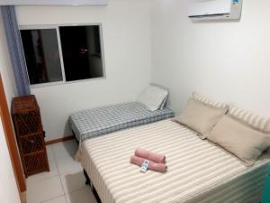 a small bedroom with two beds and a window at Lindo Village Imbassai in Mata de Sao Joao