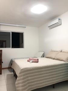 a bedroom with a large bed and a window at Lindo Village Imbassai in Mata de Sao Joao