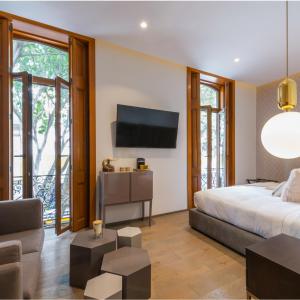 a bedroom with a bed and a tv on the wall at Casa Prim Hotel Boutique in Mexico City