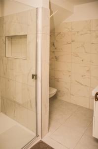 W łazience znajduje się prysznic ze szklanymi drzwiami. w obiekcie Centrum Apartman w mieście Cegléd