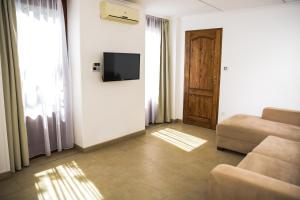 a living room with a couch and a television and a door at Centrum Apartman in Cegléd
