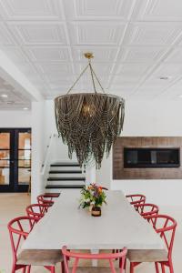 a dining room with a table with red chairs and a chandelier at RSVP Hotel in Bozeman