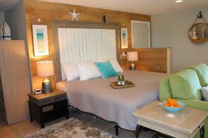 a bedroom with a large bed and a couch at Latitude 26 Waterfront Boutique Resort - Bonita Springs in Bonita Springs