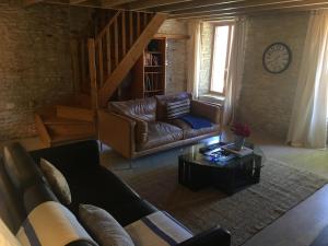 a living room with a leather couch and a coffee table at Les Trois Piliers in Saint-Clair