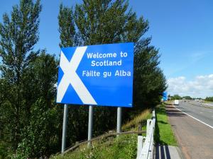 a sign for a welcome to scotland on the road at Greenlaw Guest House in Gretna Green