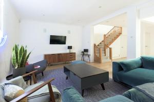 - un salon avec un canapé et une table dans l'établissement The Harrods Mews - Modern 4BDR + Rooftop & Garage, à Londres