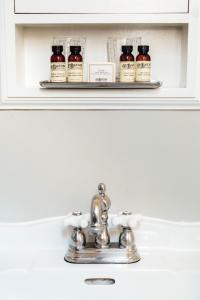 a shelf above a sink with four bottles of medicine at Hotel Normandie - Los Angeles in Los Angeles