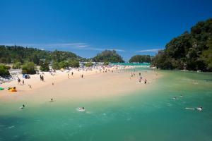 um grupo de pessoas em uma praia na água em Kaiteriteri Recreation Reserve Cabins em Kaiteriteri mais 36 fotografias