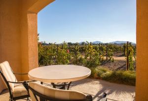 a table and chairs on a patio with a view of a vineyard at Carter Estate Winery and Resort in Temecula