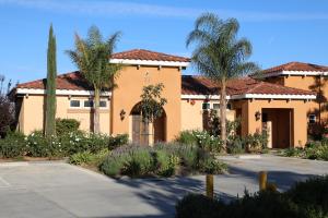 a house with palm trees in front of a driveway at Carter Estate Winery and Resort in Temecula