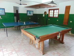 duas mesas de pingue-pongue numa sala com paredes verdes em Casa em condomínio em Barra do Sahy
