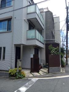 a building with a balcony on the side of a street at Kyoto LanLan in Kyoto