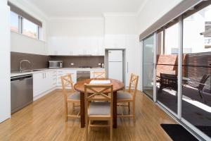 uma cozinha e sala de jantar com mesa e cadeiras em Waterstreet Apartment em Albury