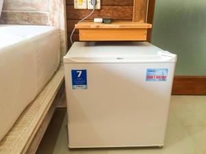 a small refrigerator in a room next to a bed at D'Tegal House in Nusa Lembongan