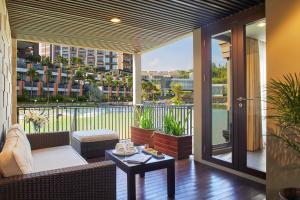 a balcony with a couch and a table at ASTON Sentul Lake Resort & Conference Center in Bogor