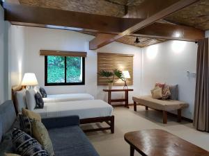 ein Wohnzimmer mit einem Bett und einem Sofa in der Unterkunft Casitas de Victoria in Nasugbu