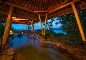 a swimming pool under a pavilion with a view of the water at Ryoso Uminocho in Ise