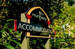 una señal para la universidad de alojamiento en un poste en The Nunnery, en Te Aroha