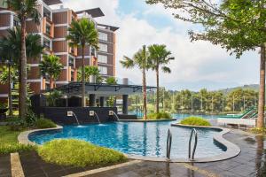 an image of a resort swimming pool with palm trees at ASTON Sentul Lake Resort & Conference Center in Bogor