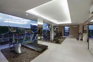 un gimnasio con equipo cardiovascular y paredes de cristal en ASTON Sentul Lake Resort & Conference Center en Bogor